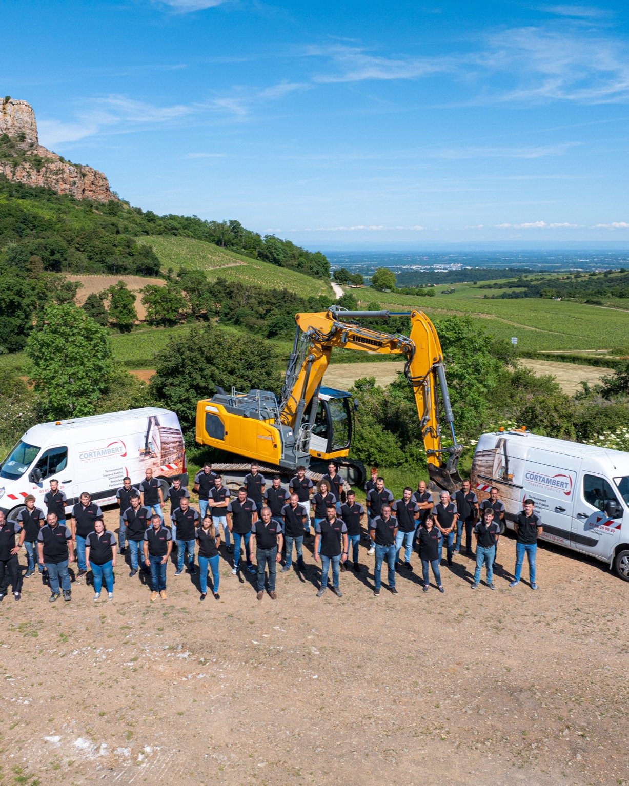 Équipe Cortambert TP devant la Roche de Solutré avec pelle Liebherr et utilitaires