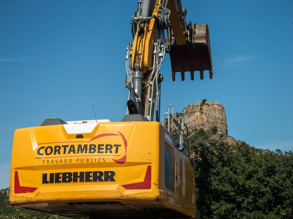 Pelle Liebherr en silhouette contre-jour au coucher de soleil sur plateforme de recyclage