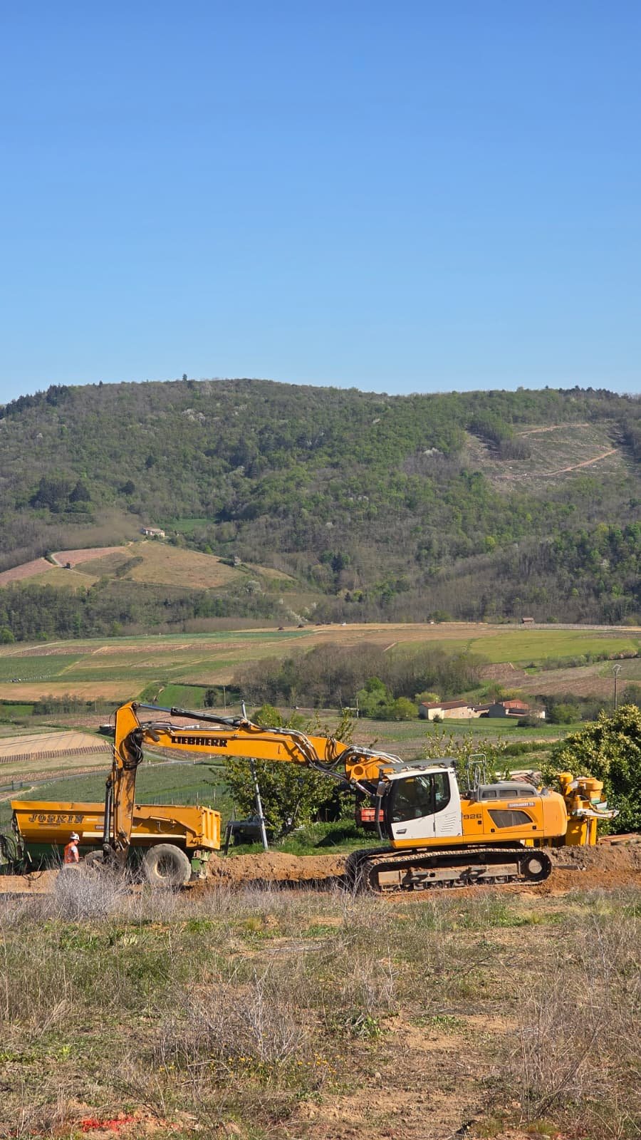 Chantier viticole — pelle Liebherr et tombereau dans les coteaux du Mâconnais